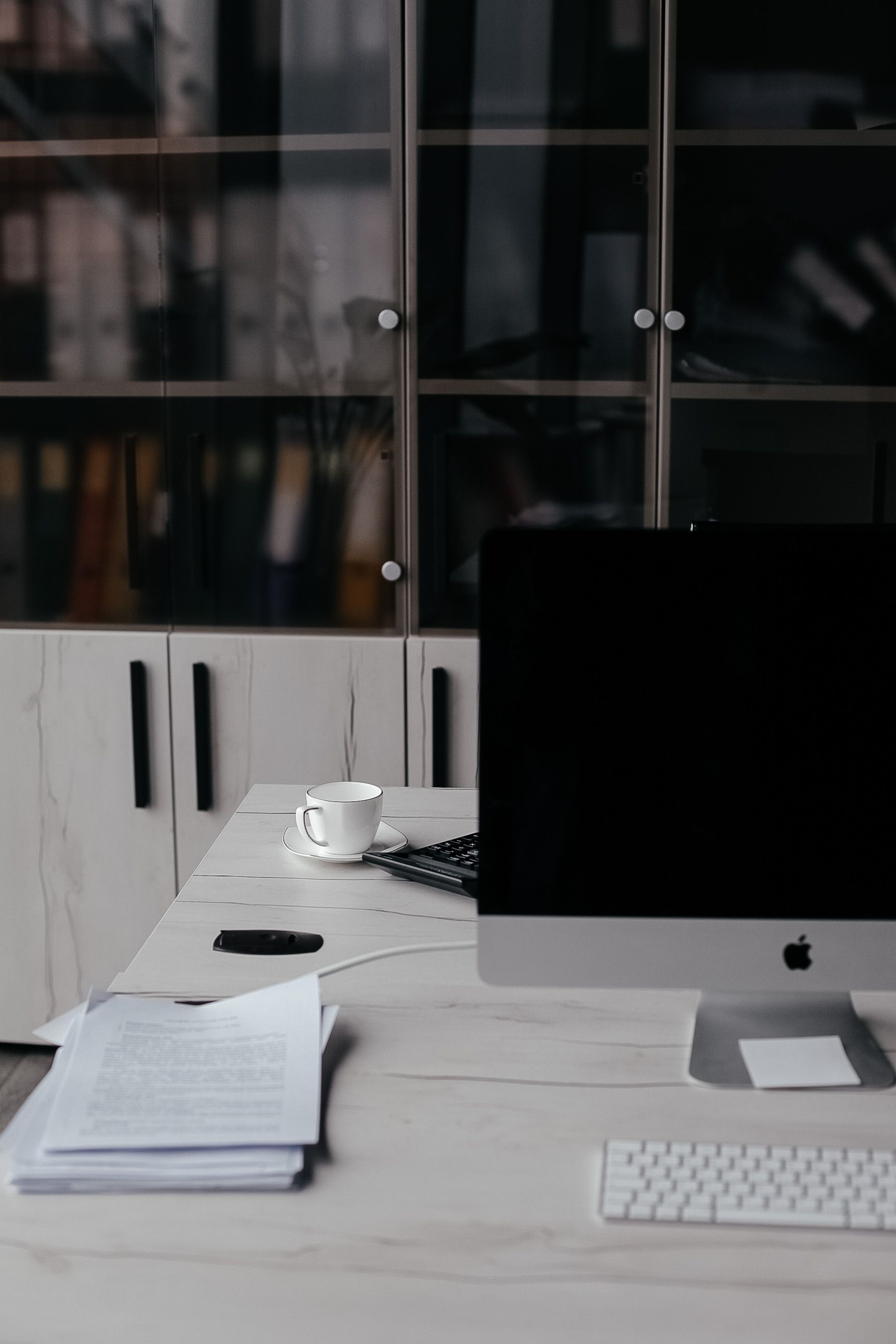 A minimalist office desk setup featuring a computer and documents, perfect for productivity.