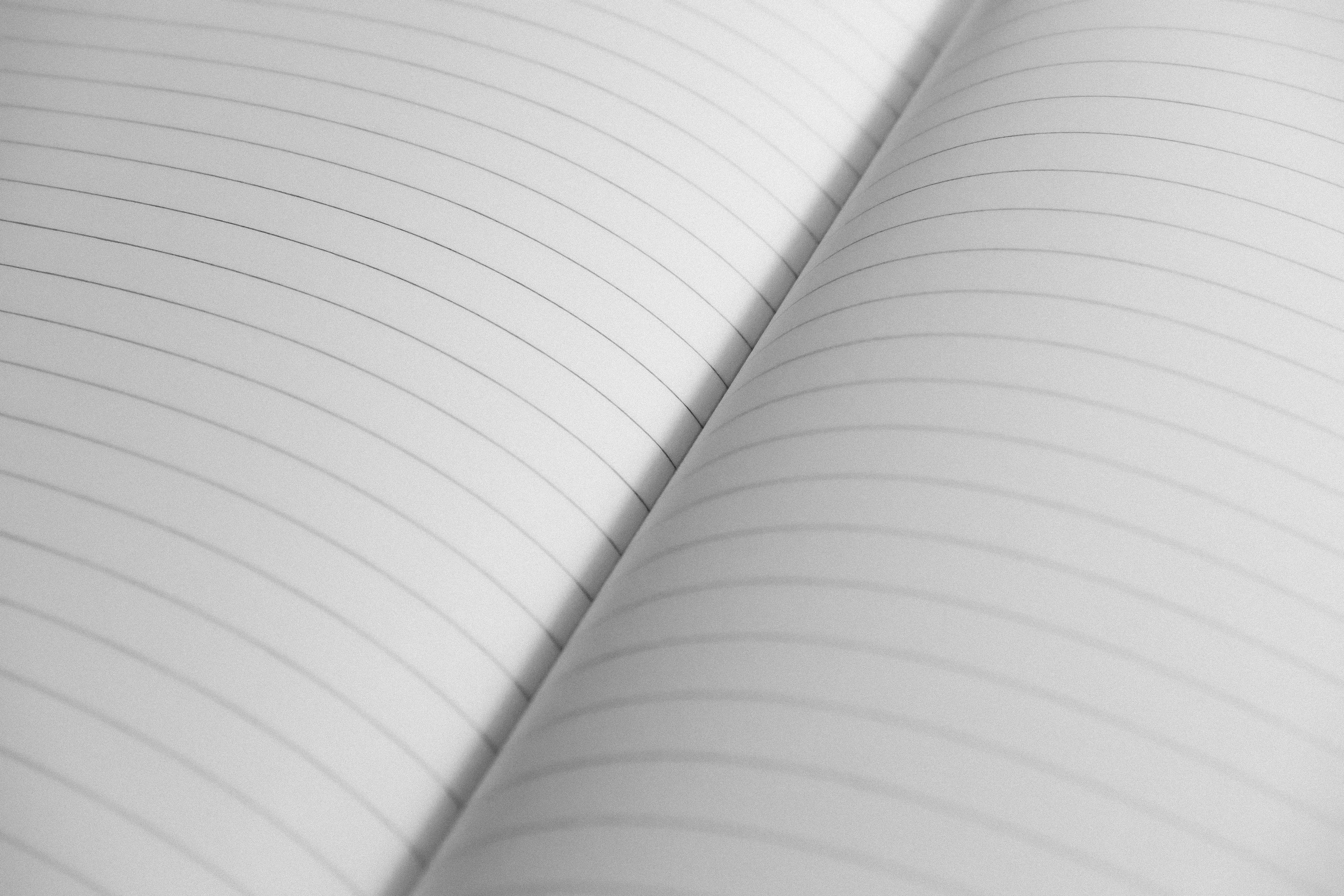 High-resolution close-up of an open notebook with lined pages, perfect for stationery concepts.