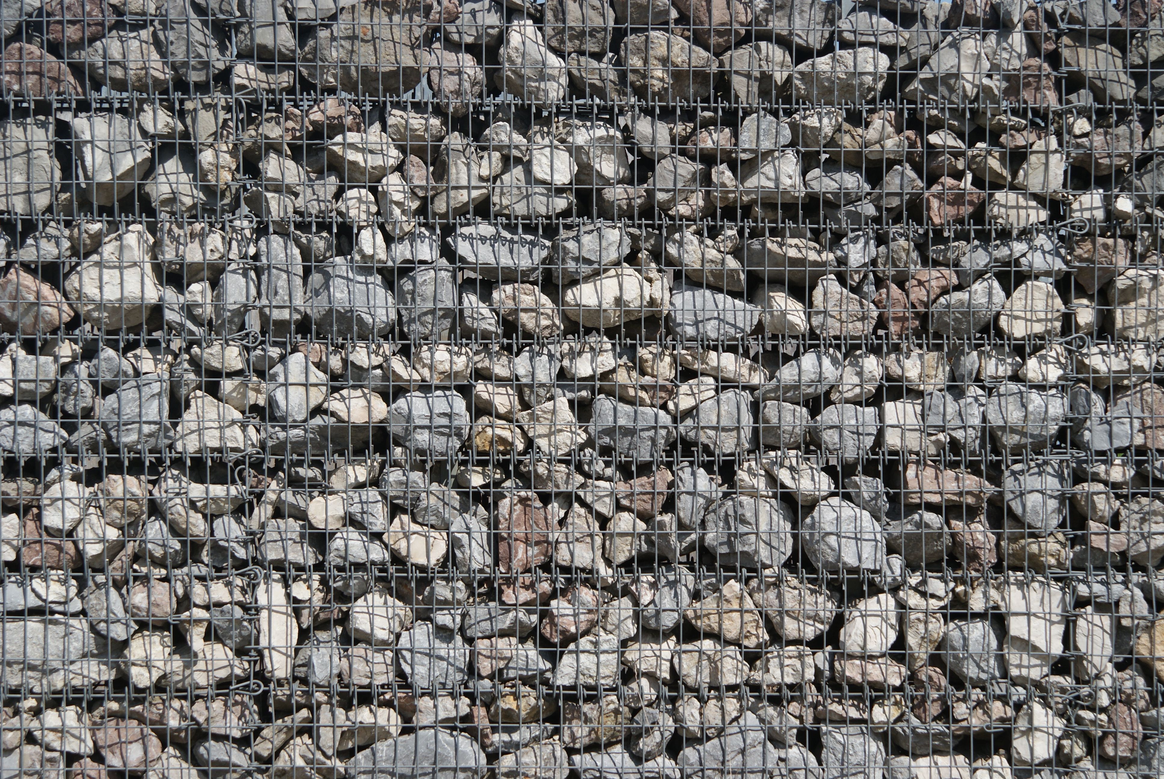 Detailed view of stones encapsulated within a sturdy wire mesh structure, showcasing texture.