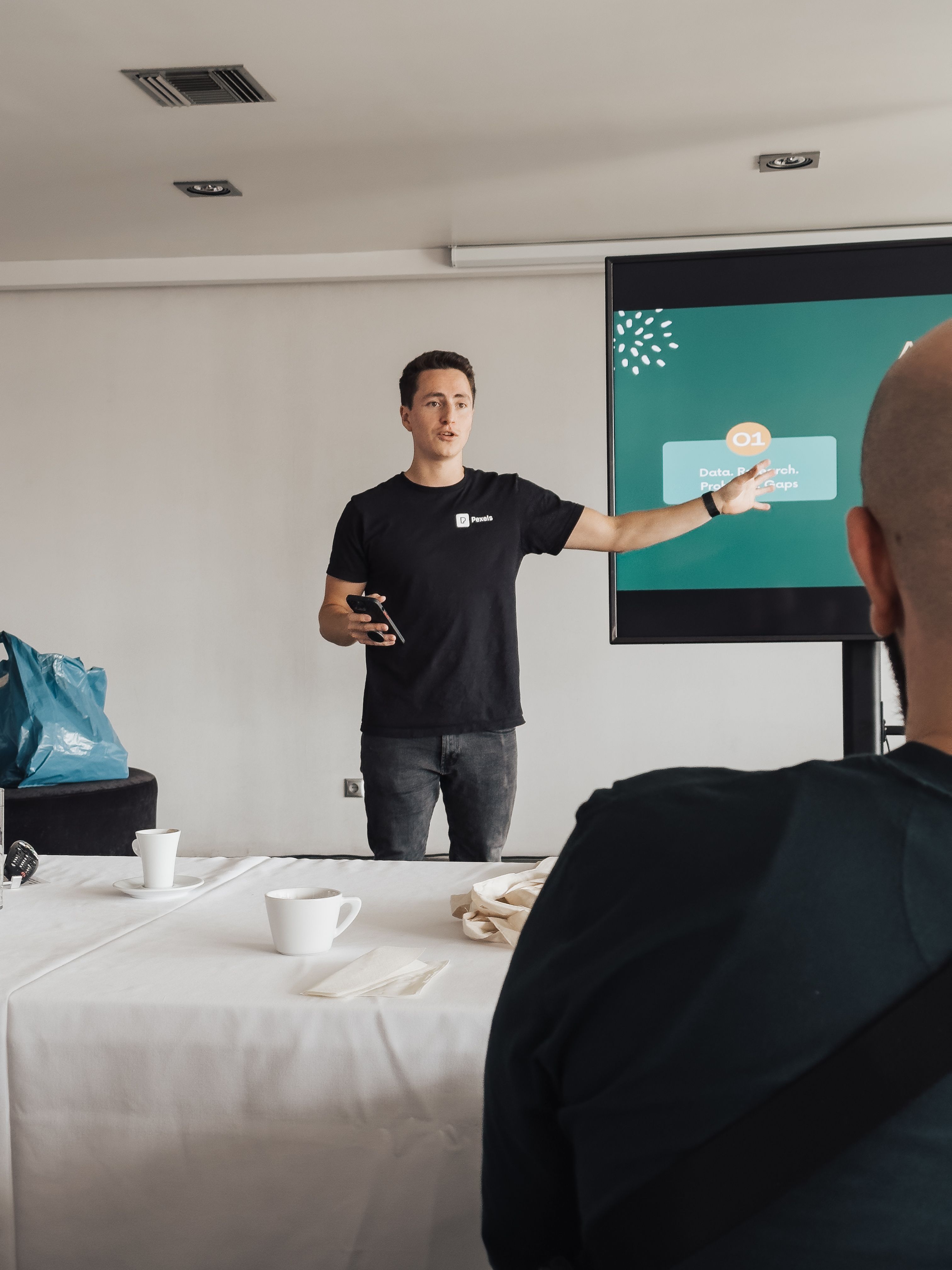 Business professional giving a presentation in a modern conference room setting.
