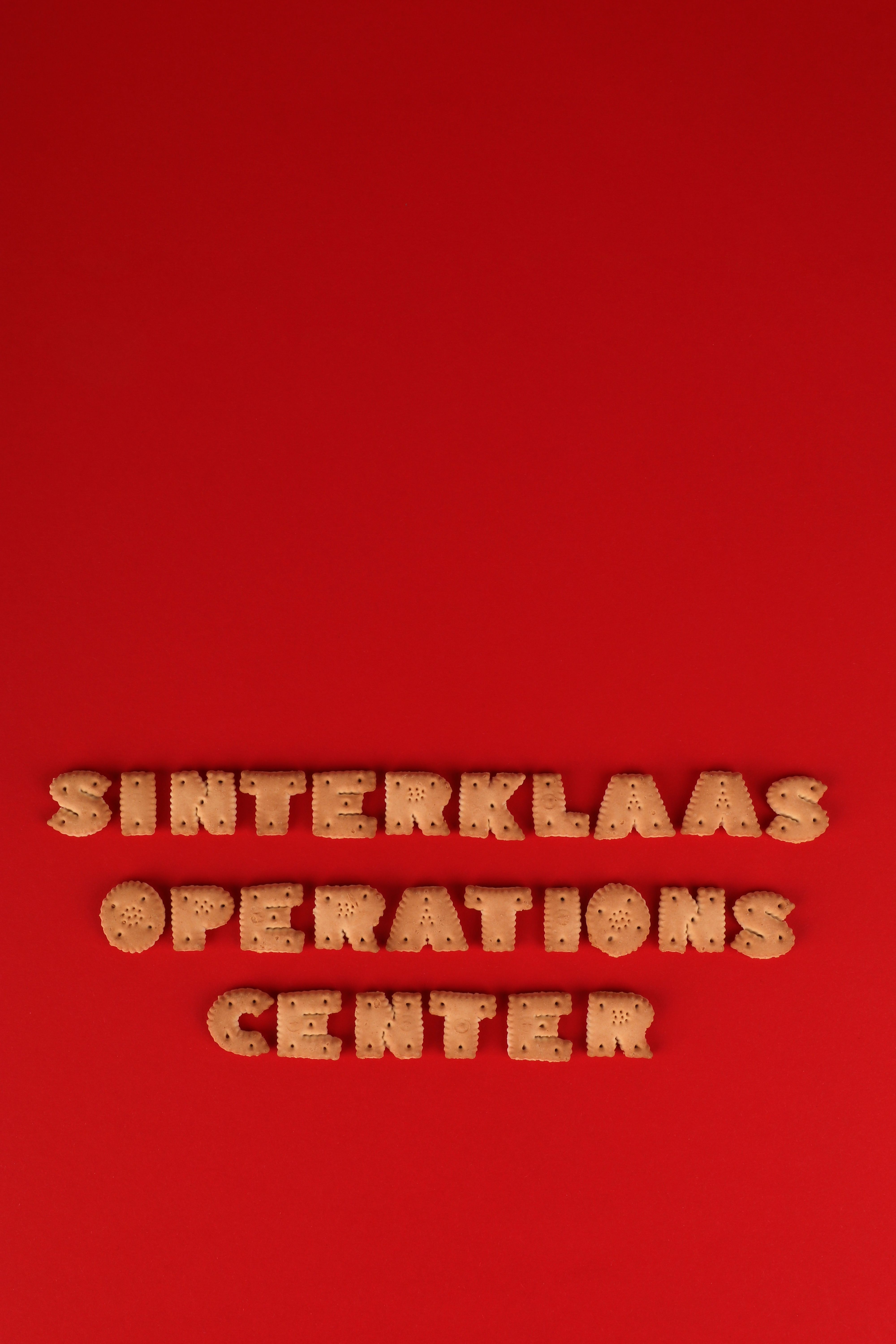 Alphabet cookies spelling 'SINTERKLAAS OPERATIONS CENTER' on a vibrant red background.