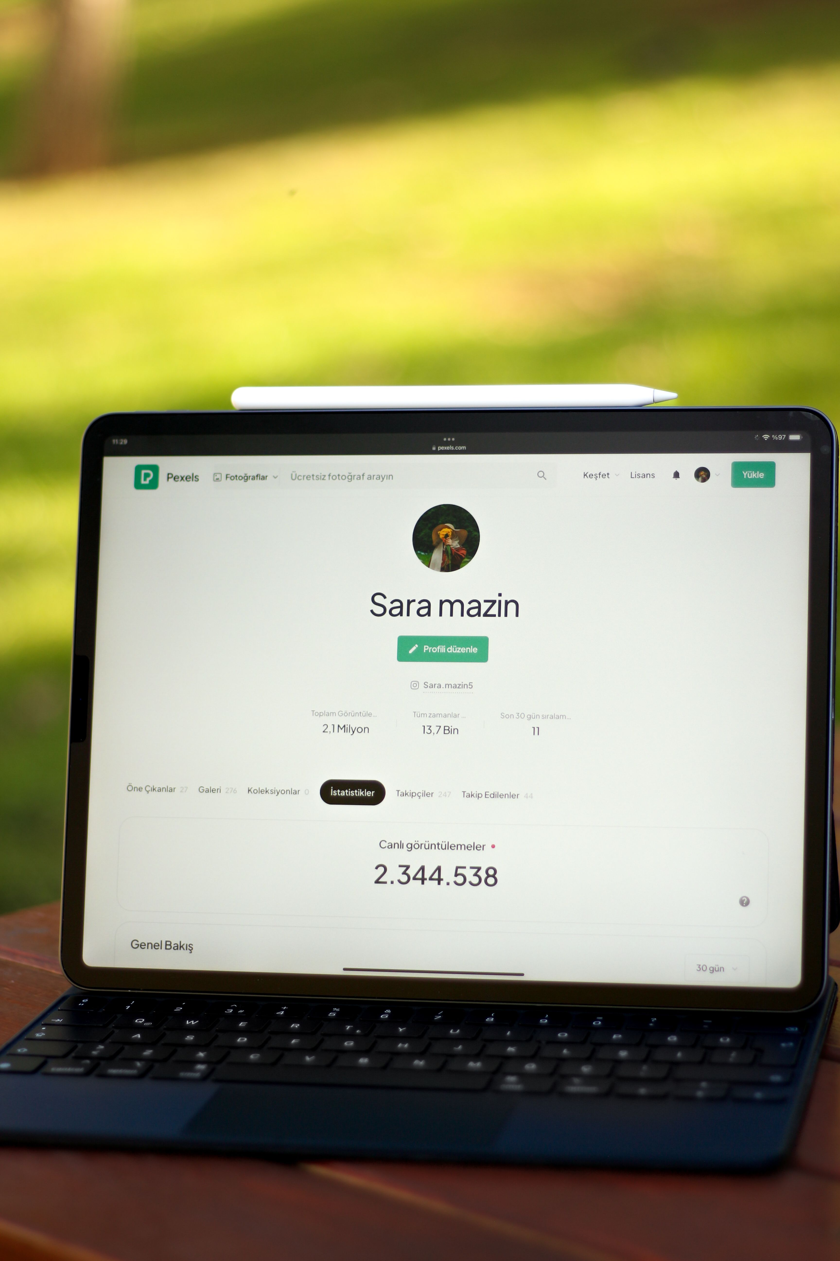 Tablet showing an online profile set on a wooden table outdoors in daylight.