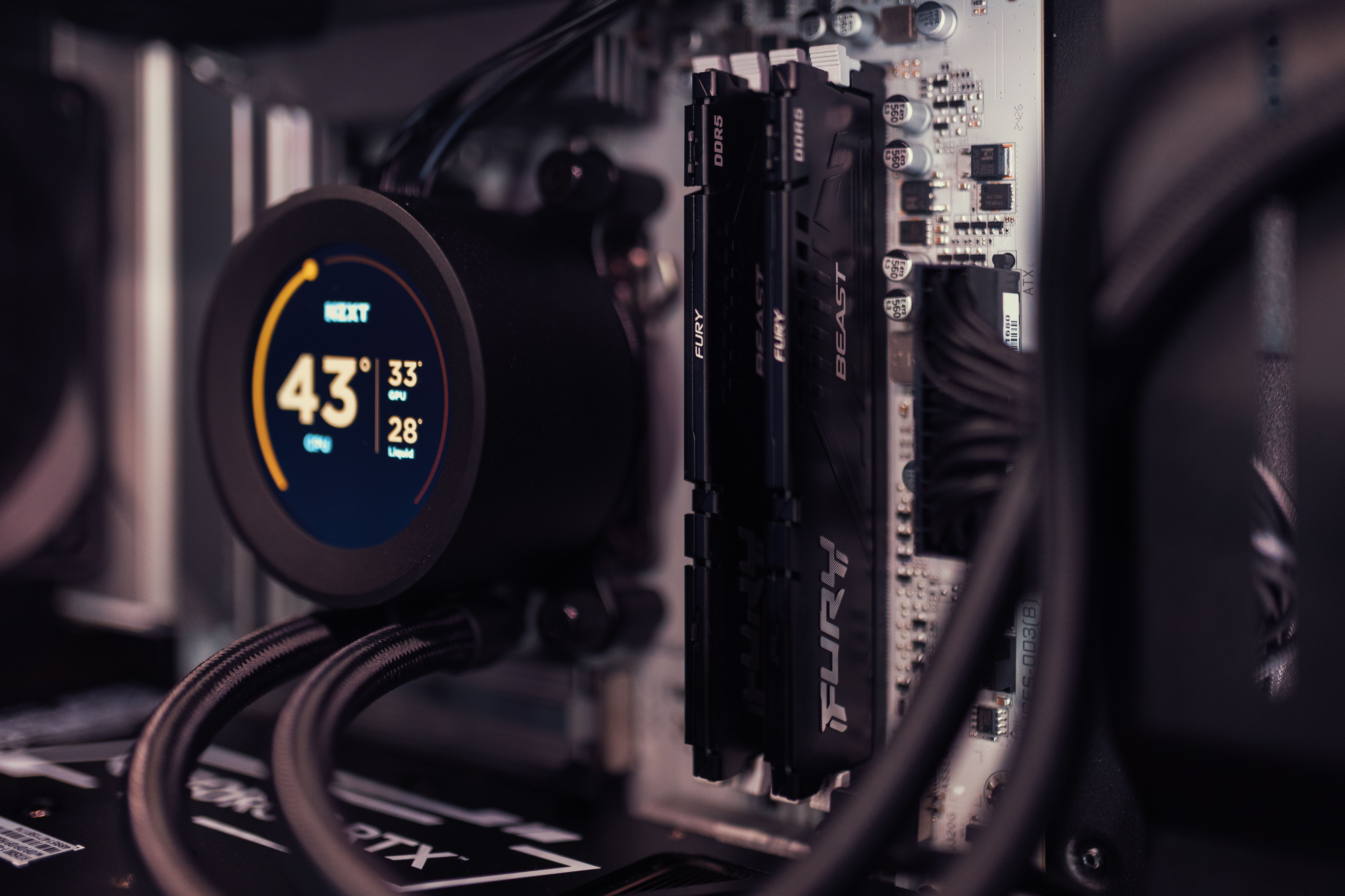 Detailed view of a gaming PC's interior featuring RAM and a digital CPU cooler display.