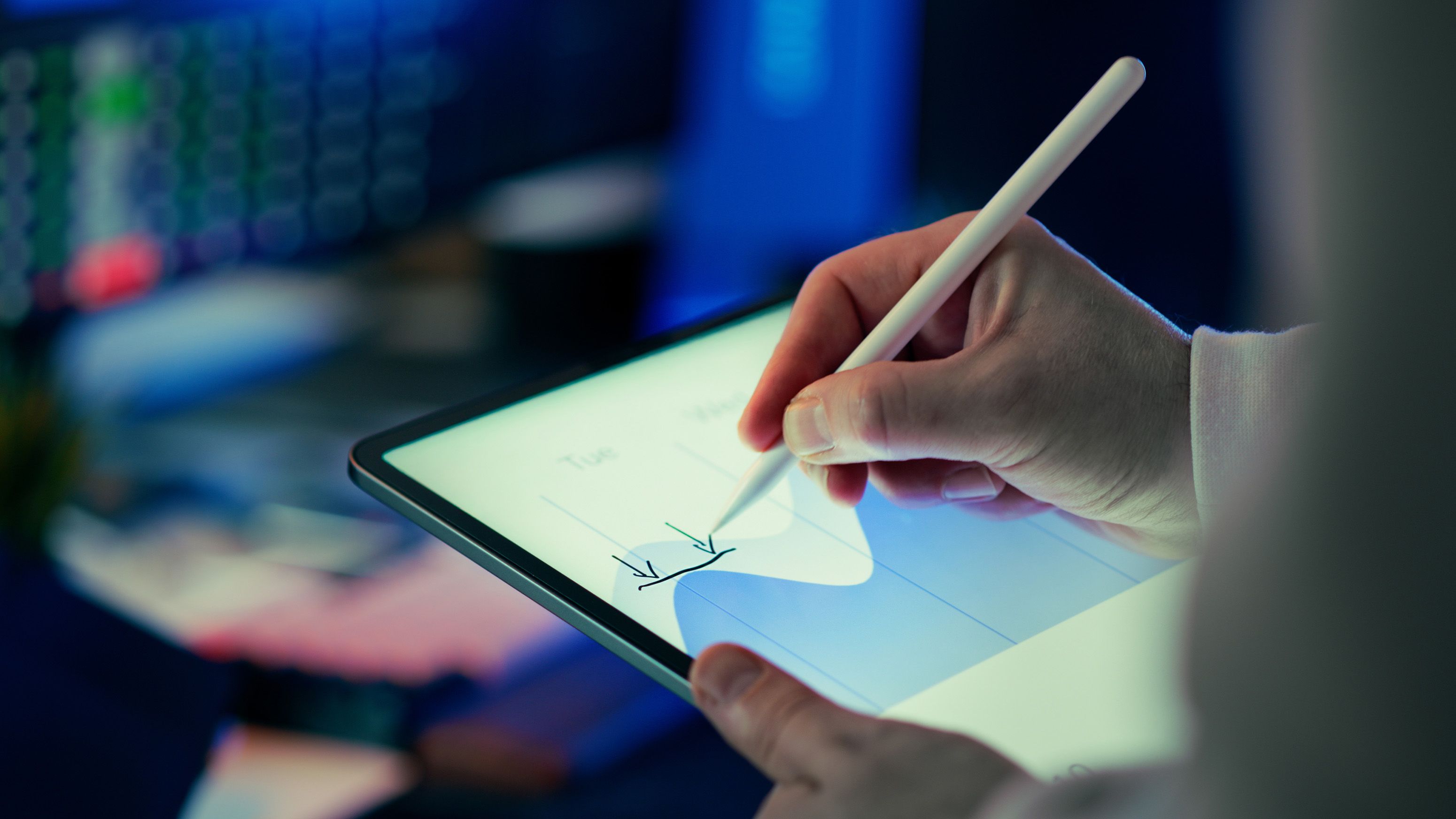 Business person using a stylus to analyze data on a digital tablet in an office setting.