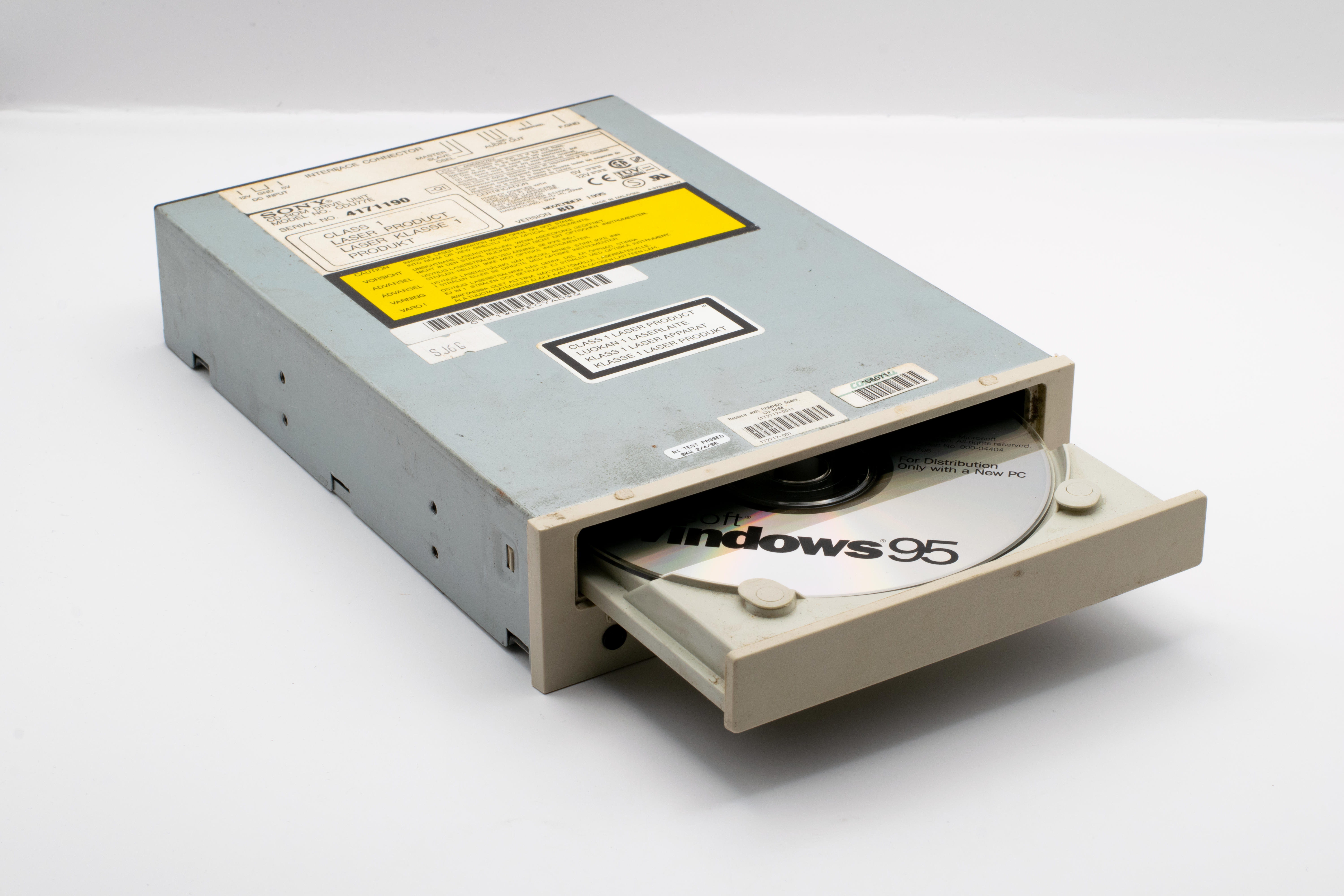 A vintage CD-ROM drive showcasing a Windows 95 disc, reflecting retro technology.