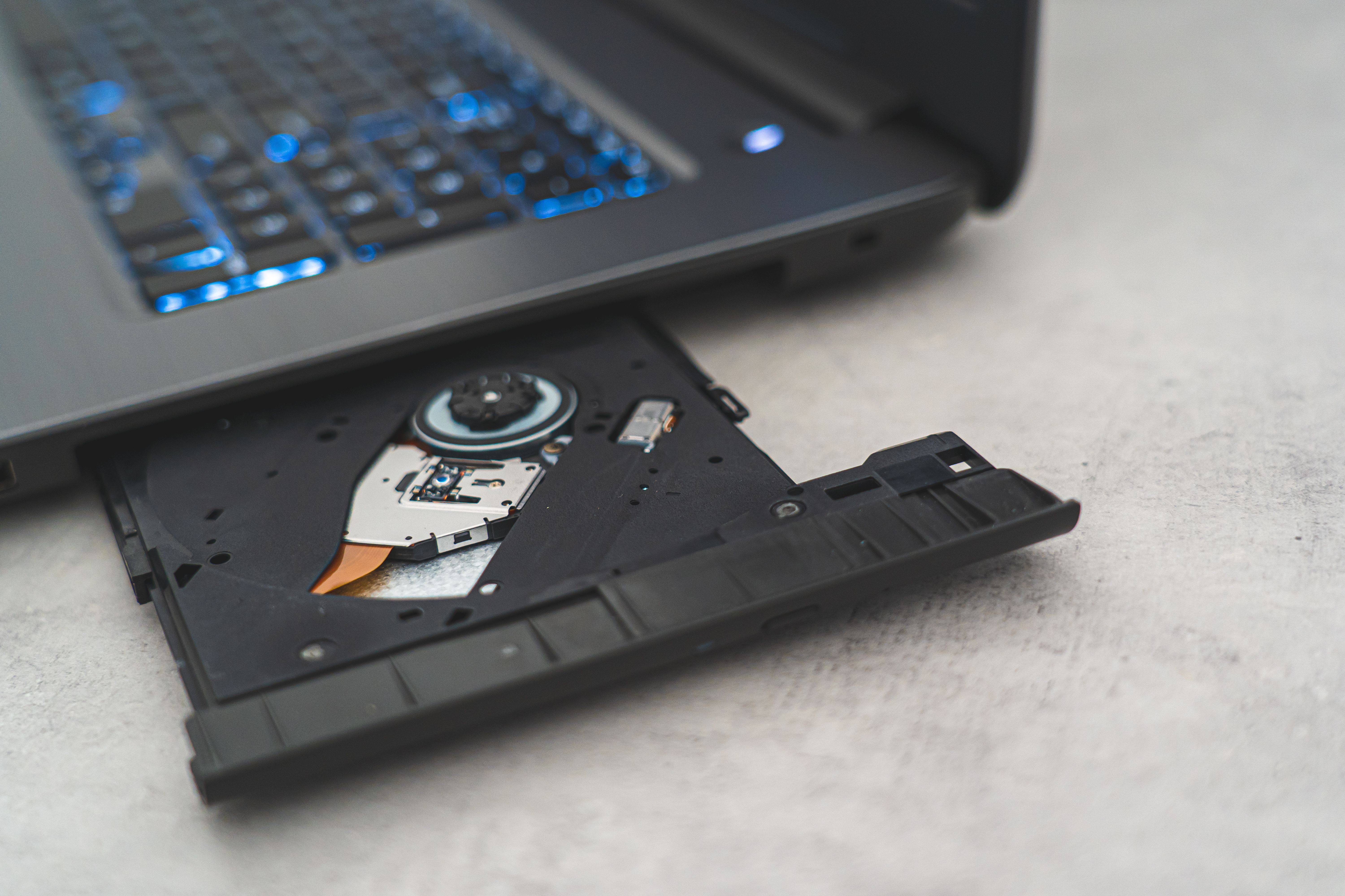 Modern laptop showing open CD drive, highlighting optical disk technology.