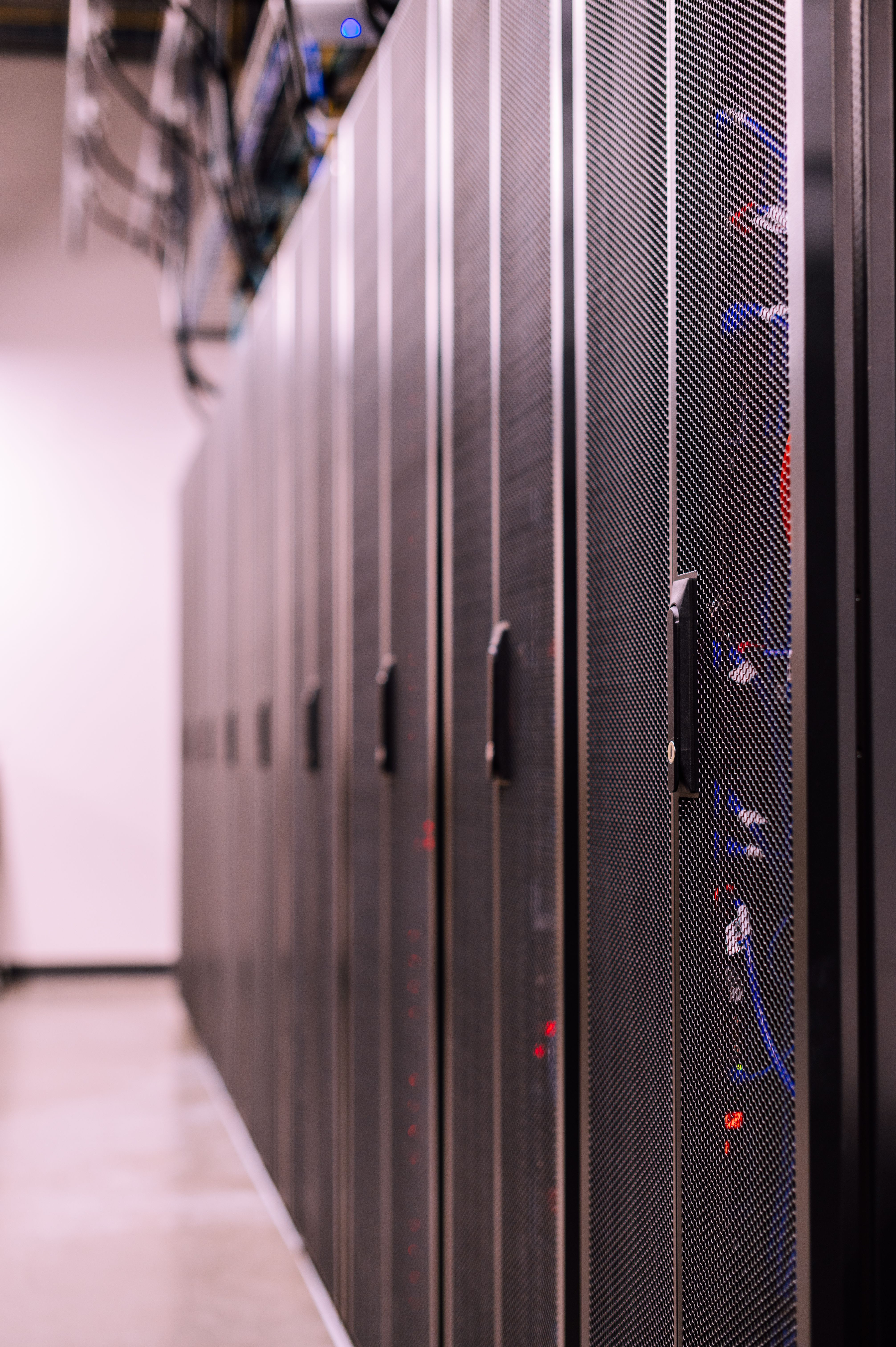 Row of similar lockers with various optic fiber cables in modern data server room