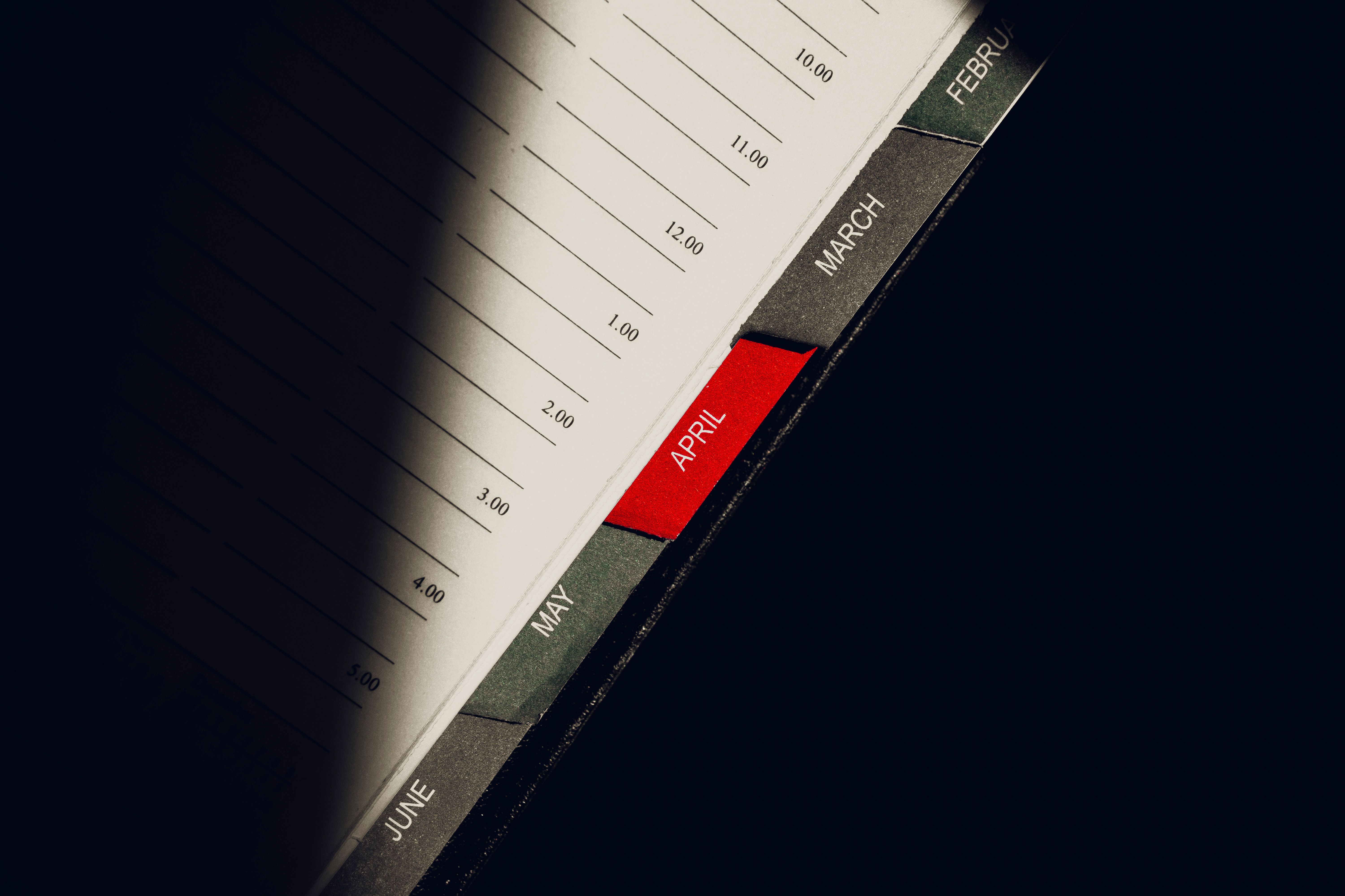 A close-up shot of a planner highlighting the month of April with visible monthly tabs.