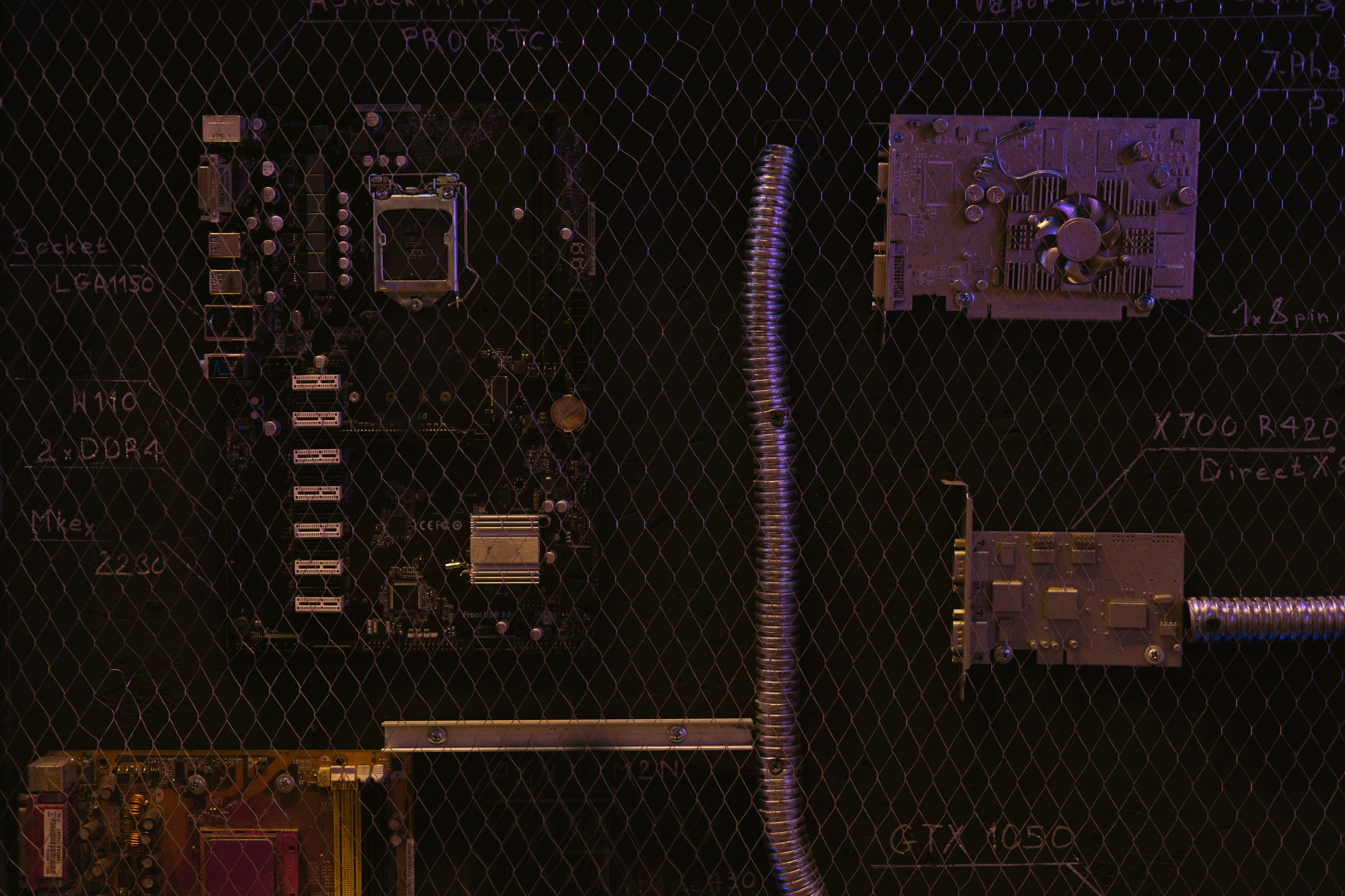 A close-up view of a motherboard and electronic components against a detailed chalkboard backdrop.