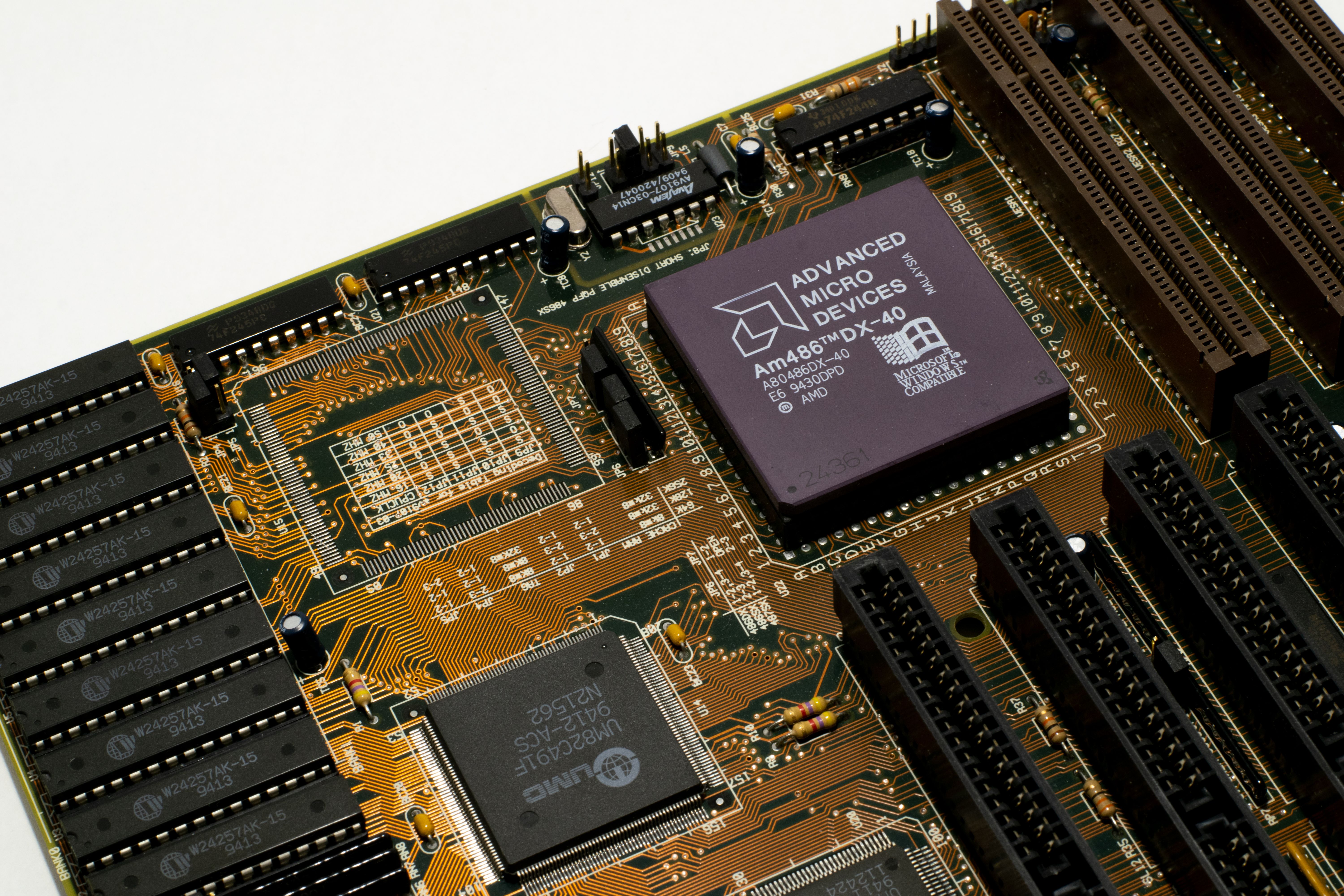Detailed view of a vintage motherboard with an AMD microchip, showcasing intricate circuitry and slots.