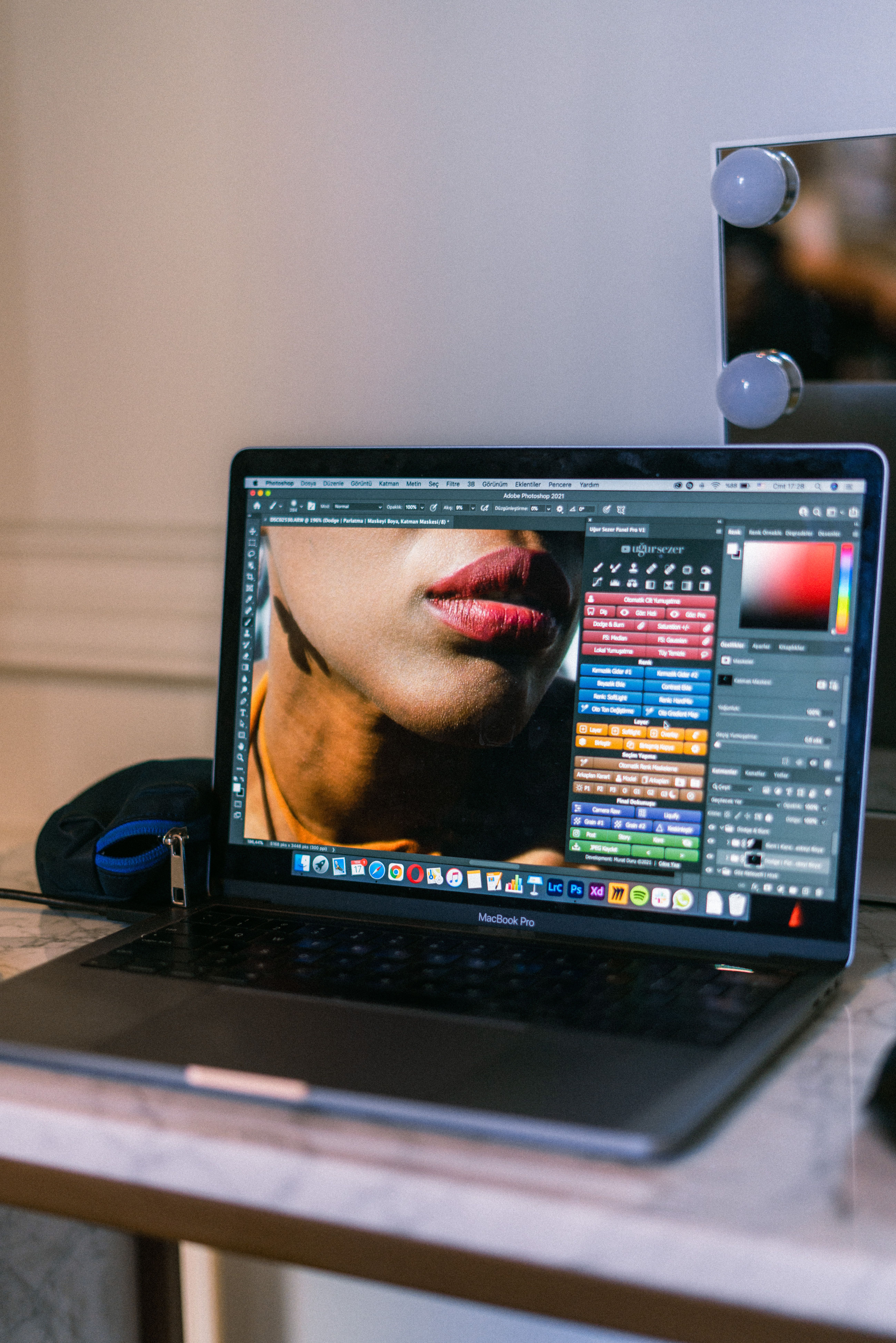 A laptop displaying a graphic design software interface in a creative workspace.